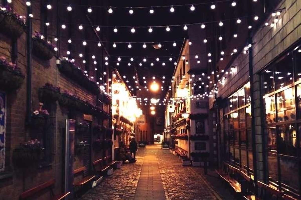 Camera luminosa con letto vestito di bianco e finestra sui tetti di Verona